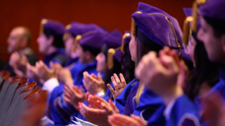 people in cap and gown clapping