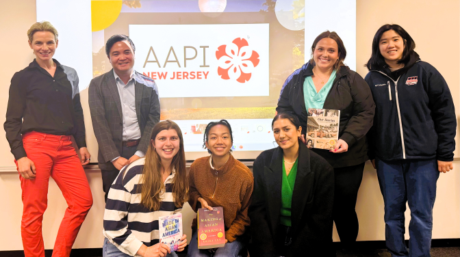 group of people pose in front of a screen