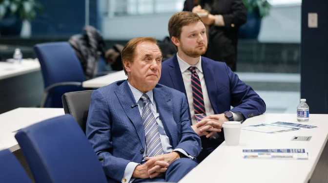 Two men seated while listening