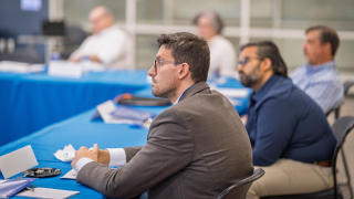 White men seated at the table listening