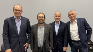 Four men posing together smiling 