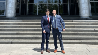 Two men standing in front of a building