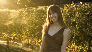 White woman with long hair smiling with sun shining on her