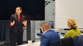A Latina wearing suit speaking to an audience