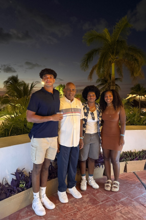 Group of black people pose next to palm trees
