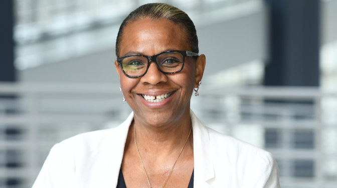 A spectacled black woman smiling