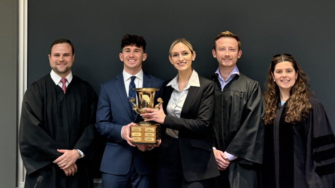 A group of people holding a trophy.