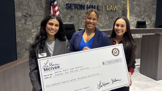 three women pose with a check