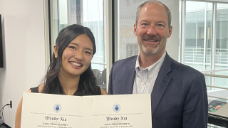 Asian woman and white man holding certificates 