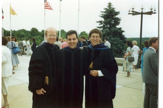 Three men standing together smiling