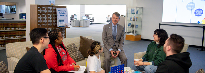 Image of Interim Dean Cornwell with law school students in one of the lounges of Rodino Center.