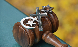 A gavel with religious symbols.