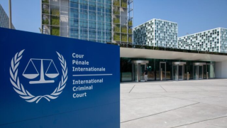 A blue sign in front of buildings