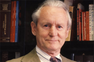 Judge John J. Gibbons standing in front of a book shelf