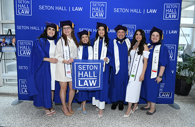 LLM Graduates Posing in caps and gowns. 