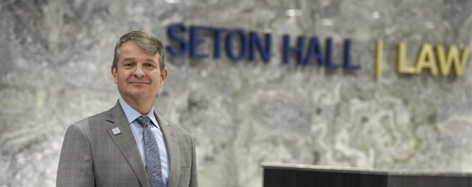 Image of Dean Cornwell in front of Seton Hall law sign.