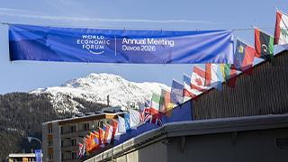Blue Banner held up in air next to several country flags